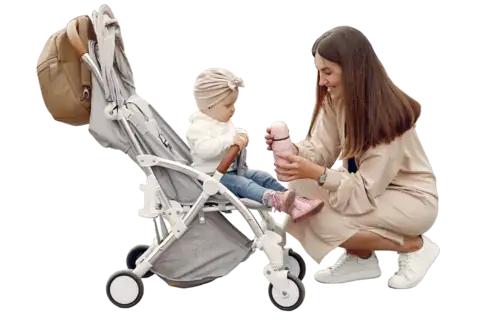 Una giovane mamma passeggia nel parco autunnale con il passeggino